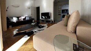 Una sala moderna con sofá, televisor y mesa de centro.