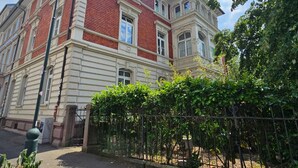 Un edificio de ladrillo rojo con detalles blancos y varias ventanas.