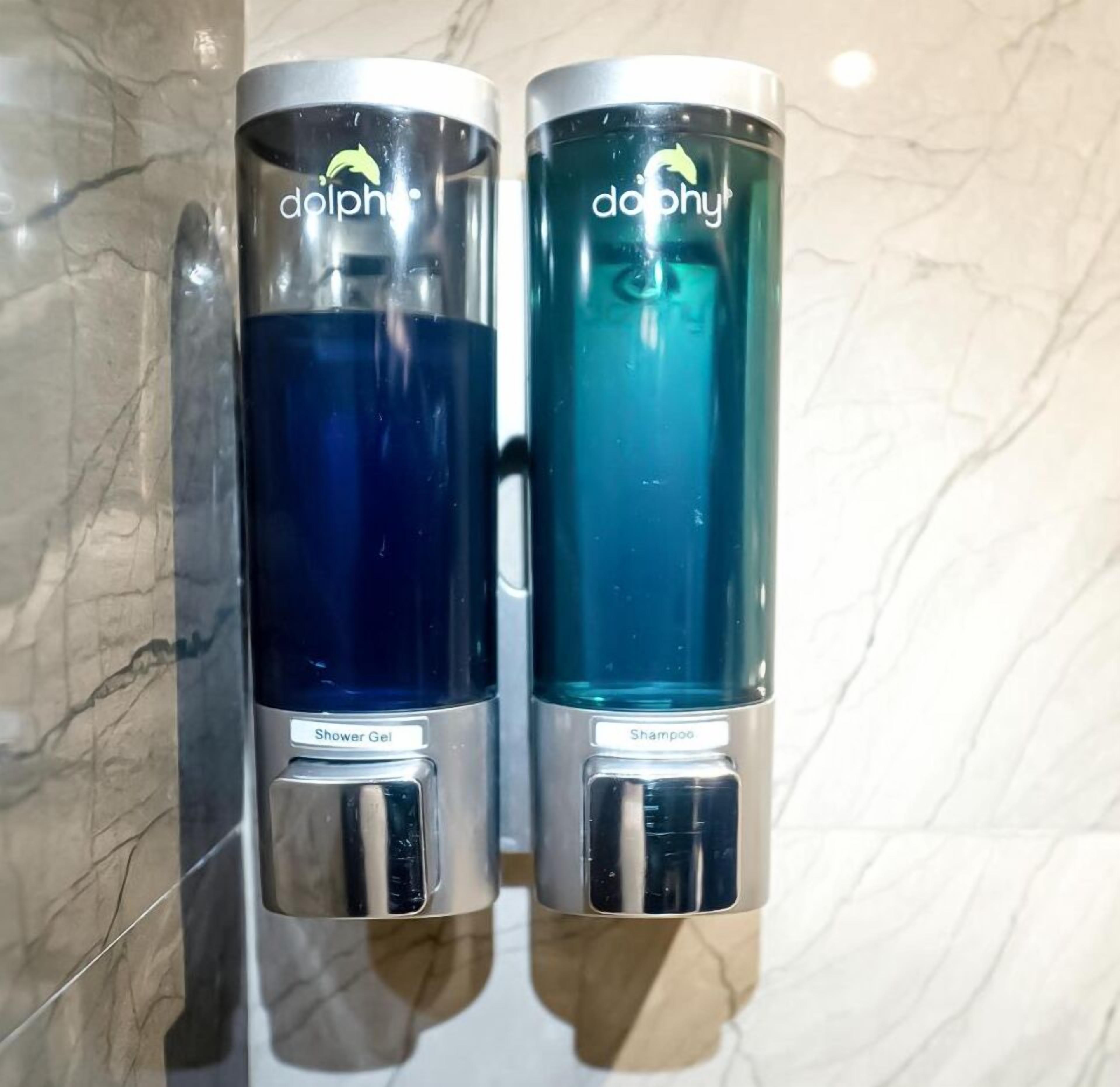 Two wall-mounted dispensers labeled 'dolphy' with 'Shower Gel' and 'Shampoo' respectively.