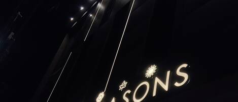 A sign with the text "ALL SEASONS" against a dark background.