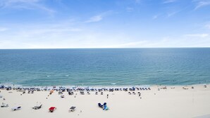 Una playa con muchos sombrillas y gente.