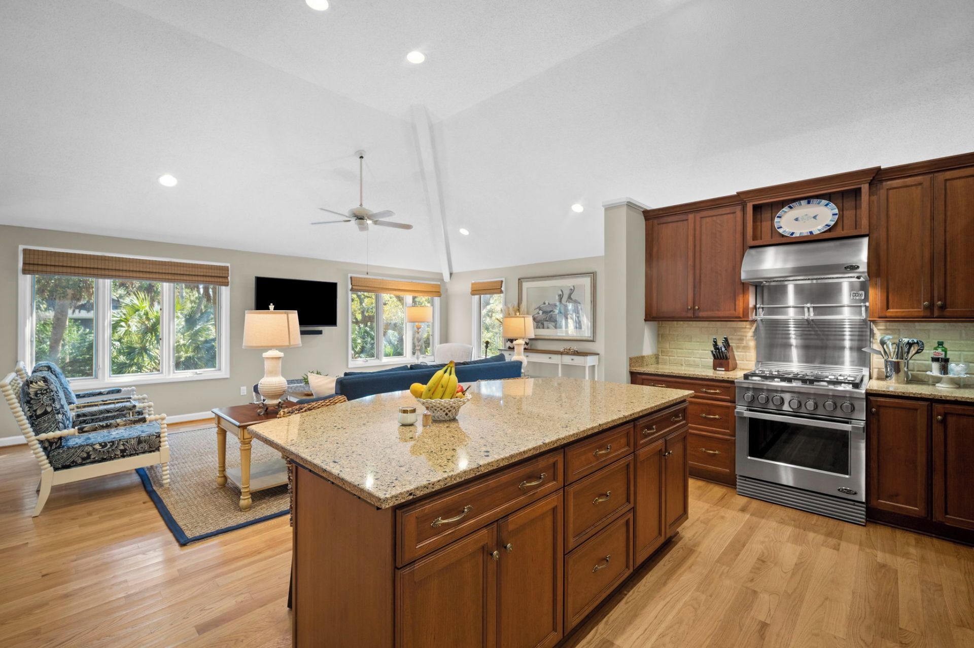 A spacious kitchen with wooden cabinets, a large island, and a stainless steel range hood.