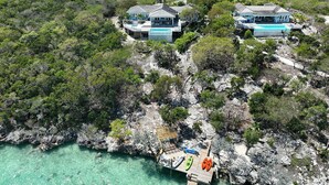 A coastal property with multiple houses, a dock, and clear turquoise waters. - Bakari House - Luxury Oceanfront Villa w/ Spectacular View, Pool, Spa and Dock (Hartswell)