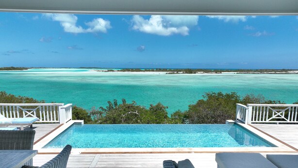 An infinity pool with a view of a turquoise sea and a clear sky. - Bakari House - Luxury Oceanfront Villa w/ Spectacular View, Pool, Spa and Dock (Hartswell)