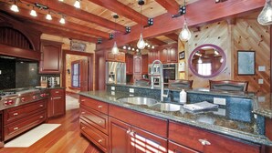 A spacious kitchen with wooden cabinets, granite countertops, and modern appliances.