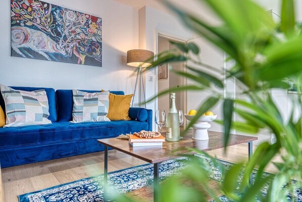 Relax in this stylish living room with a sofa, floor lamp, and a beautiful abstract painting.