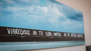 A wall with a painting of a sky and clouds, and a sign with text.