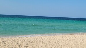 Una platja amb aigua turquesa cristal·lina i un tram de sorra.