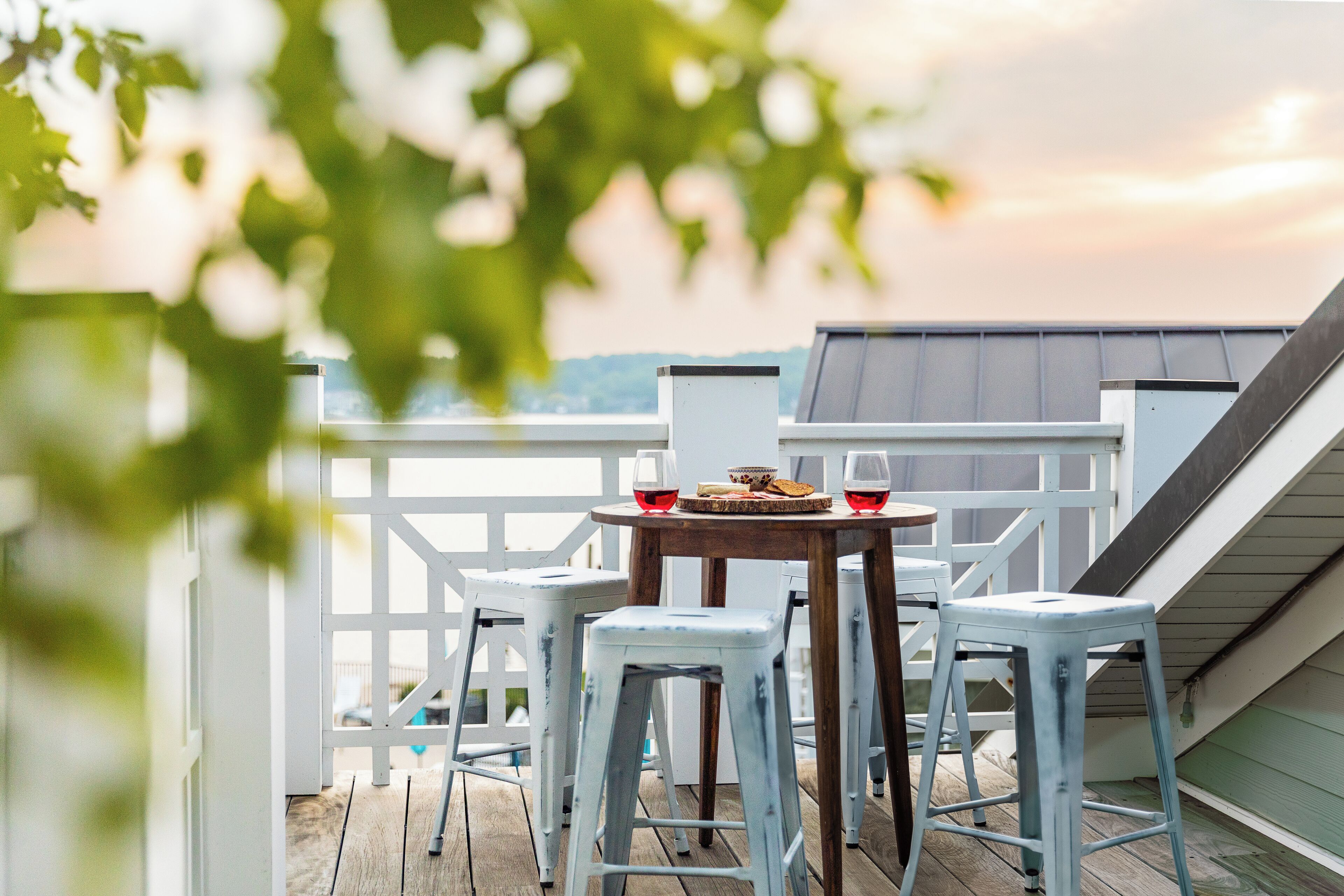 Una terraza con una mesa y cuatro taburetes, con vistas panorámicas.