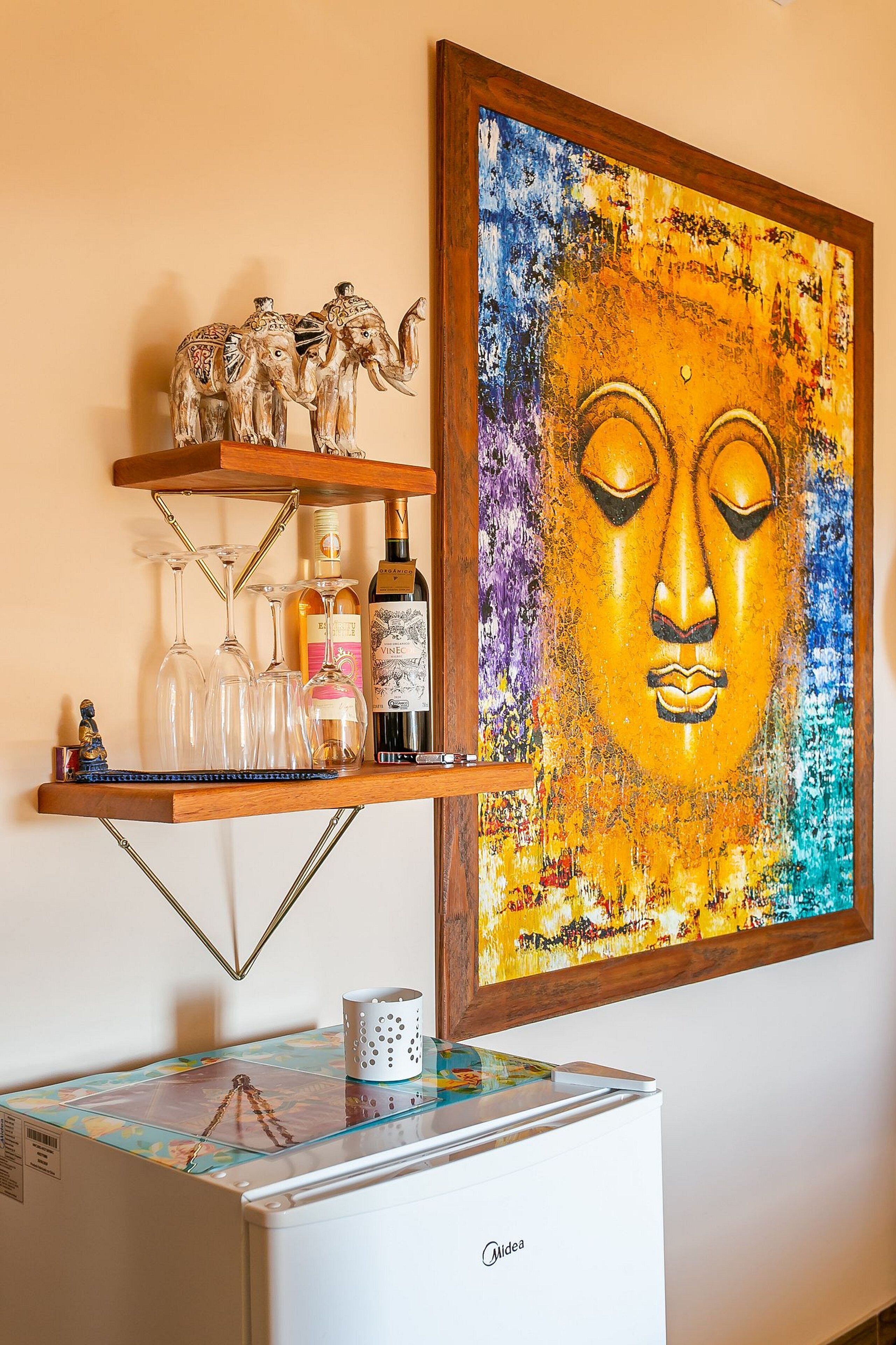 Een wandplank met decoratieve objecten en een Boeddha-schilderij.