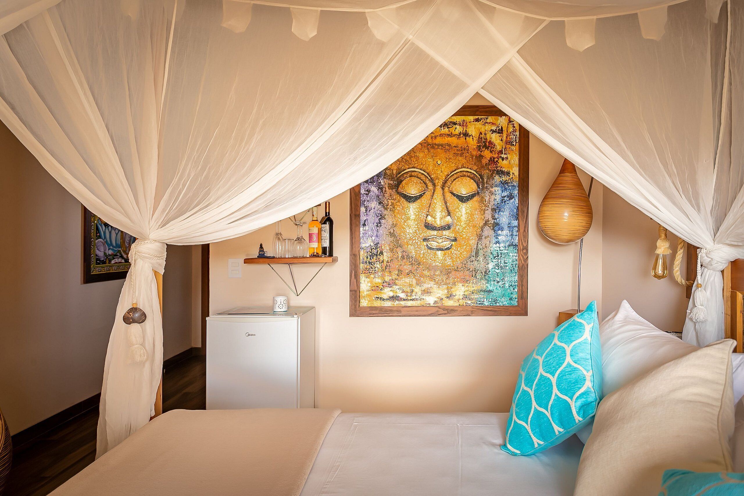Un dormitorio con cama, mesita de noche, lámpara y un cuadro.