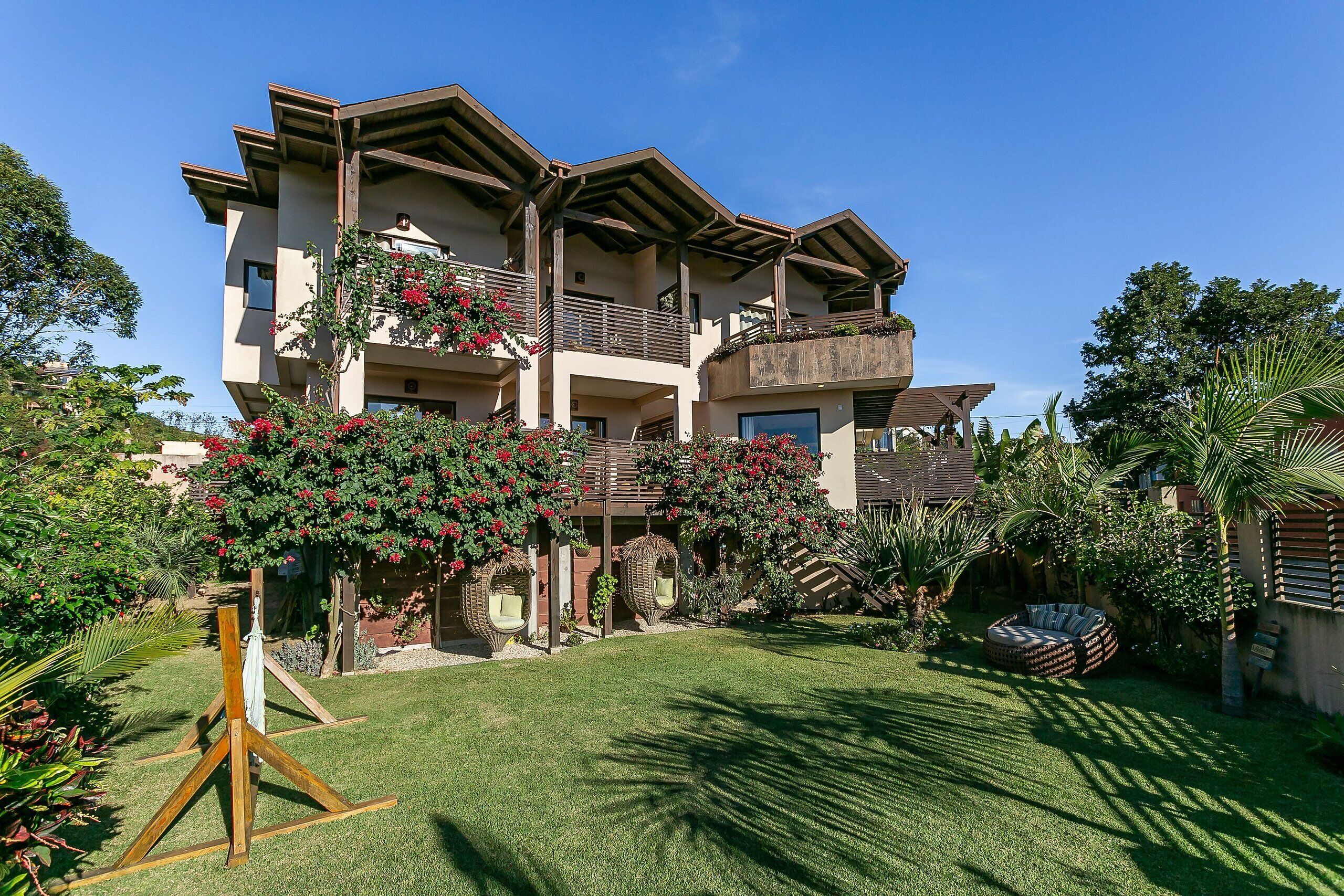 A multi-story building with balconies, a well-maintained lawn, and outdoor seating areas.