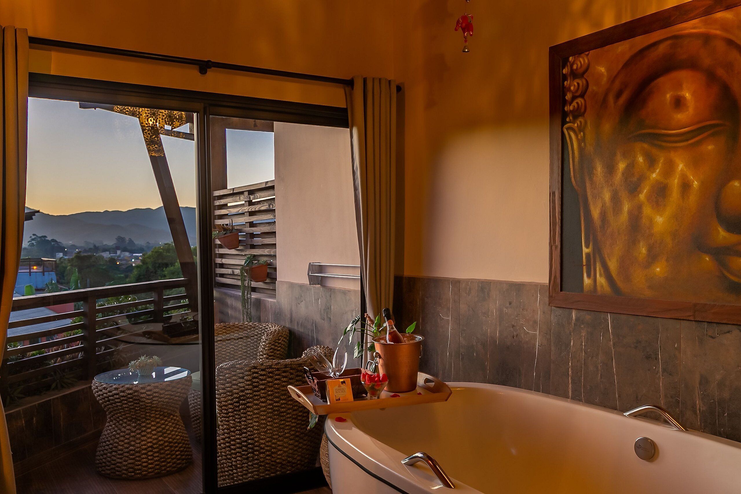 Un baño moderno con una bañera grande, cabina de ducha con mampara de vidrio y vistas al exterior.