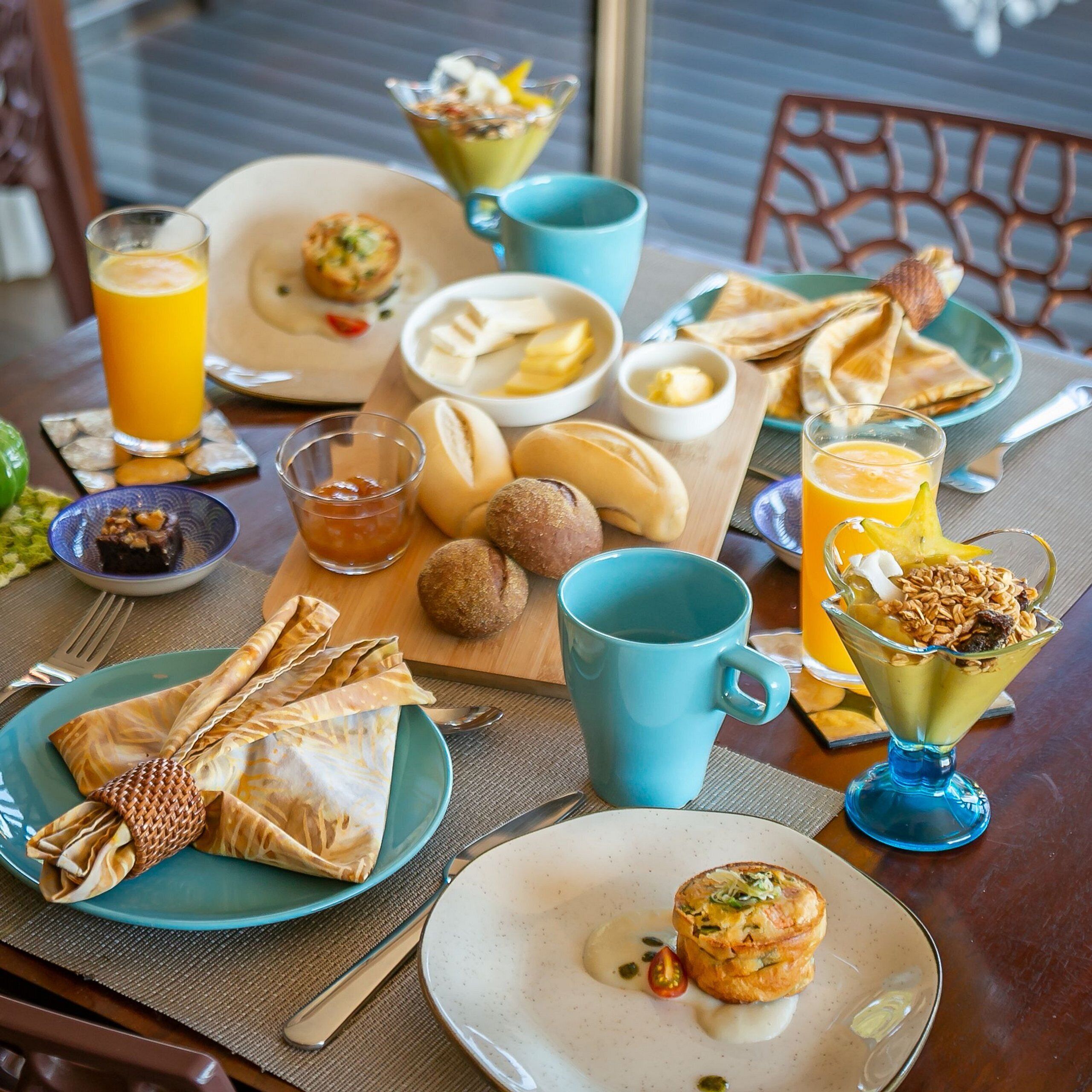 A breakfast table with various dishes, including pastries, fruits, and beverages.