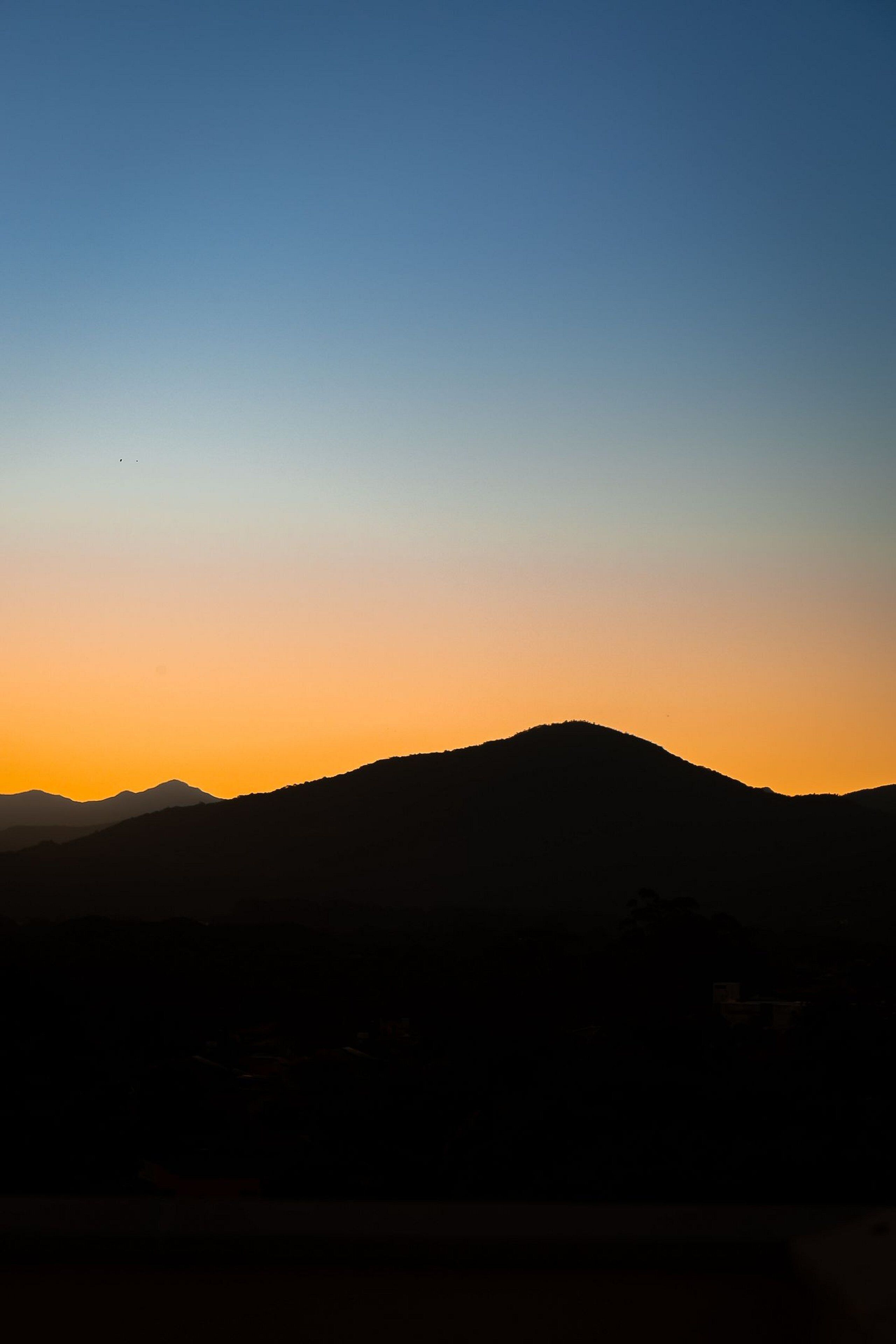 Silueta de una montaña contra un cielo al atardecer.