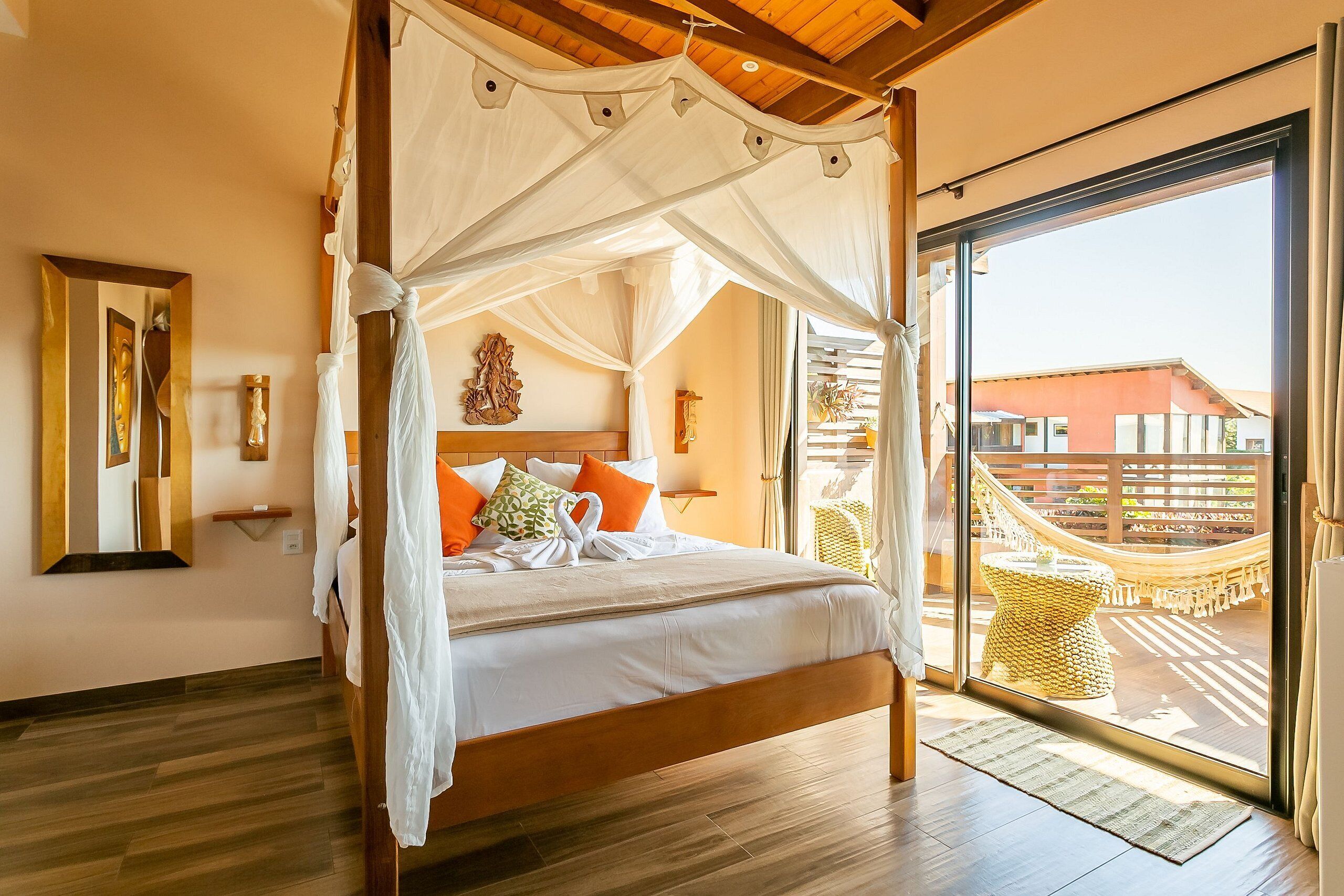A spacious bedroom with a canopy bed, a large window, and a view of the outside.