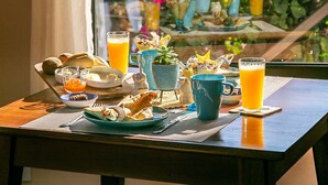 A breakfast table with a view of a lush garden and mountains. - Shiva Boutique Hotel - Praia do Rosa (Imbituba)