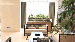A modern living room with a sofa, coffee table, and a plant display. - Mengzhiyuan Business Leisure Hotel (Danyang)