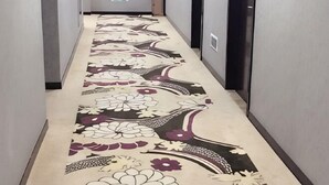 A hallway with a patterned carpet and a door on the right. - Mengzhiyuan Business Leisure Hotel (Danyang)