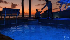 A pool area with a bench and a person standing by the pool. - Luxumas: Unveiling the Extraordinary - All-New, Fully-Staffed Luxury Eco Resort (Exumas)