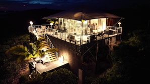 A high-rise building with multiple levels, outdoor seating areas, and a staircase leading to the upper levels. - Luxumas: Unveiling the Extraordinary - All-New, Fully-Staffed Luxury Eco Resort (Exumas)