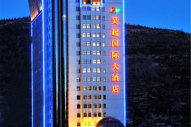 Un immeuble d’hôtel à plusieurs étages, avec une enseigne bien visible affichant des caractères chinois.