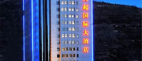 A hotel building with multiple floors and a prominent sign with Chinese characters.