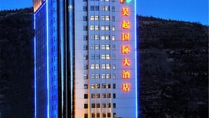 A hotel building with illuminated signage in red and yellow.