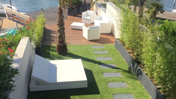 A rooftop terrace with a pool, outdoor seating, and a view of the marina.