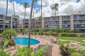 Hotel com várias varandas, piscina e áreas de estar ao ar livre.