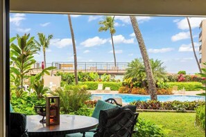 A view of a swimming pool with palm trees and a well-maintained garden. - Ground floor, oceanview 1 bedroom condo, steps from amenities, walkable area (Lahaina)