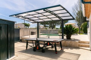 An outdoor table tennis table with a canopy, set up on a patio with a pool in the background. - Villa Margot, stunning pool, beach 500 m (Agde)