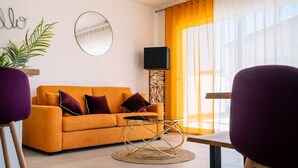 A living room with a sofa, a round table, and a lamp. - Villa Juxta Maré, Beach 500 m Away (Sérignan)