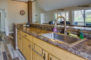 Enjoy meals in this kitchen with a central sink and adjacent dining area offering a view of the outdoors.