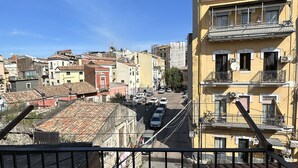 Un quartiere residenziale con diversi edifici, tra cui un edificio giallo con balconi e uno rosso con tetto in tegole.