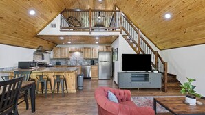 Ein großzügiger Loft-Wohnbereich mit Küche, Essbereich und einer Treppe zu einer erhöhten Ebene.
