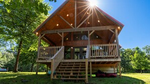 Eine Holzhütte mit Balkon, einer Treppe und einem überdachten Veranda.