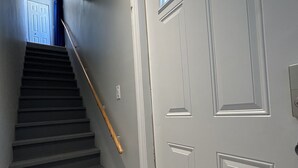 Una escalera que lleva a una puerta con un ventanal encima.