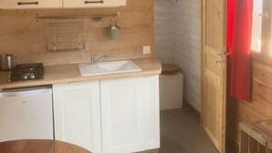 Une cuisine de taille réduite, avec des meubles de rangement en bois, un évier et une cuisinière.