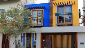 A two-story building with a modern design, featuring a combination of blue and yellow colors. - POUSADA LAZULI (Macaé)
