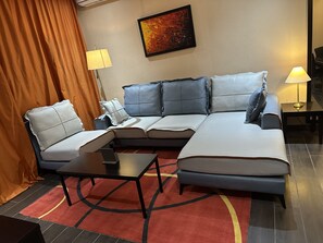 Suite – signature, 1 kingsize-seng, byutsikt, executive-nivå | Oppholdsområde | En 65-tommers smart-TV med digitale kanaler