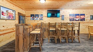 Un interior de madera con una zona de bar, diversas opciones de asientos y obras de arte colgadas en la pared.
