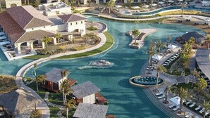 Ein Resort mit großem zentralen Pool, mehreren Gästevillen und einer gepflegten Landschaft.