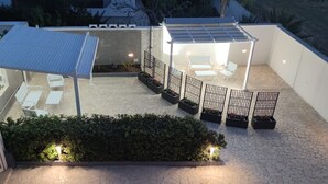 A rooftop patio with seating, a pergola, and a garden area. - MELOGRANO apartment near sandy beach (Campomarino)
