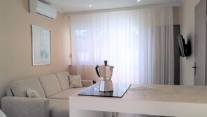 A modern living room with a sofa, a coffee table, and a TV mounted on the wall.