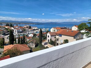 A coastal town with traditional architecture, a marina, and a view of the sea. - Guesthouse Cecilia (Malinska-Dubasnica)