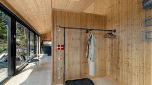 A wooden interior with a metal rack, a flag, and a mat. - 3 bedroom cozy home in Blokhus (Blokhus)