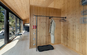 Un intérieur en bois avec un présentoir métallique, un drapeau et un tapis.