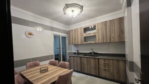 Eine moderne Küche mit Holdekor, einer schwarzen Arbeitsplatte und einem Essbereich mit Holztisch und -stühlen.