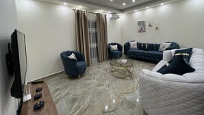 Ein modernes Wohnzimmer mit Flachbildfernseher, zwei Sofas, einem Couchtisch und einem TV-Schrank.